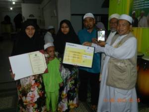 Penerima Anugerha Kecemerlangan SPM Nurul Nazurah Mohamad Fadzli bersama ibu bapanya untuk menerima Anugerah Kecemerlangan Imam Hamzah
